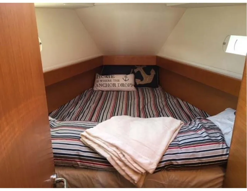 Slide: The Image of Cozy cabin interior of 2017 Jeanneau Sun Odyssey 44 DS with striped bedding and nautical decor. - 9