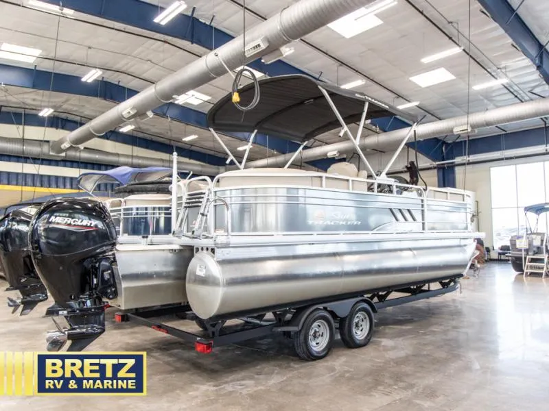 Slide: The Image of 2023 Party Barge 22 RF XP3 pontoon boat in showroom, featuring Mercury outboard motor. - 5