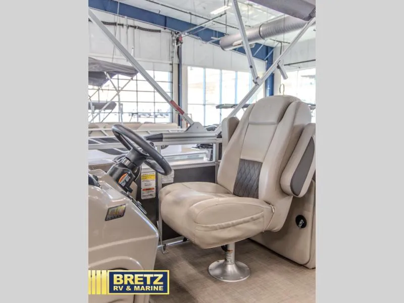 Slide: The Image of 2023 Party Barge 22 RF XP3 captain's chair and steering wheel in showroom. - 7