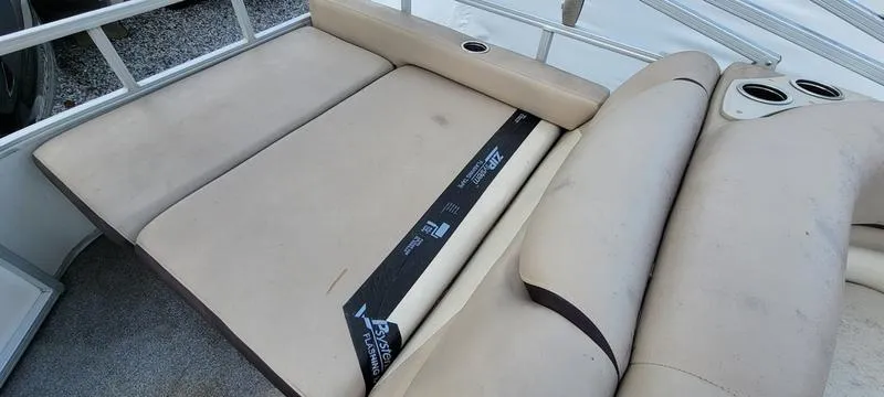 Slide: The Image of 2016 Sun Tracker PB 22 RF boat seating area with beige upholstery and cup holders. - 14