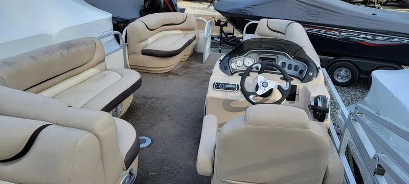 Slide: The Image of Interior of a 2016 Sun Tracker PB 22 RF pontoon boat with beige seating and steering console. - 5