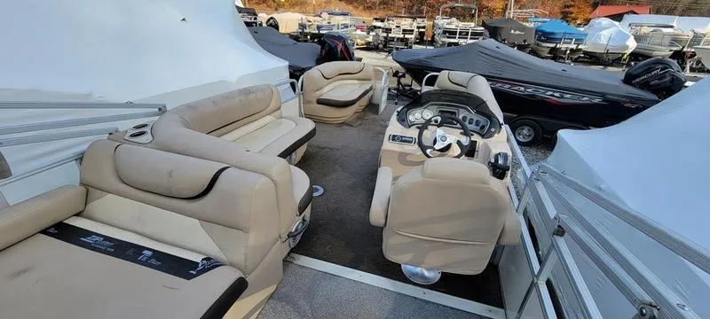 Slide: The Image of 2016 Sun Tracker PB 22 RF pontoon boat interior with beige seating and steering console. - 6