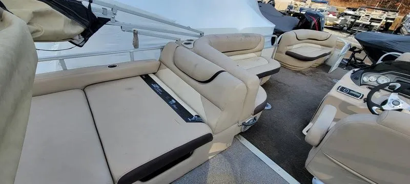 Slide: The Image of 2016 Sun Tracker PB 22 RF pontoon boat interior with beige seating and steering console. - 7