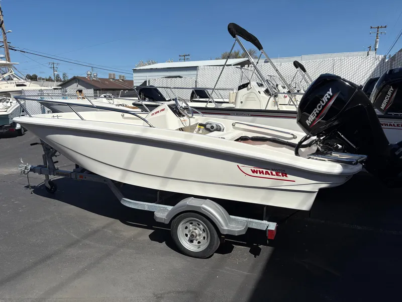 The Image of 2025 Boston Whaler 130 Super Sport boat on trailer, featuring Mercury outboard motor. - 0