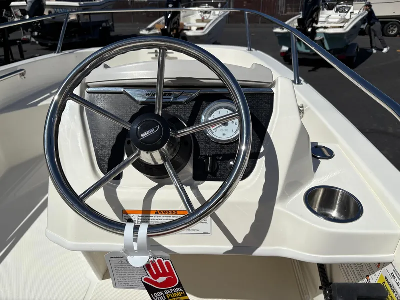Slide: The Image of 2025 Boston Whaler 130 Super Sport steering console with stainless steel wheel and gauges. - 6