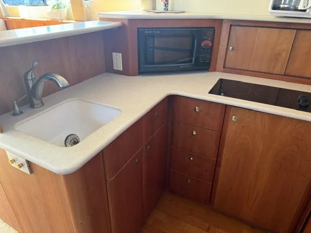Slide: The Image of 2002 Silverton 330 Sport Bridge kitchen with sink, microwave, and stove. - 12