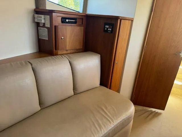 Slide: The Image of Interior of 2002 Silverton 330 Sport Bridge with beige leather seating and wooden cabinetry. - 14