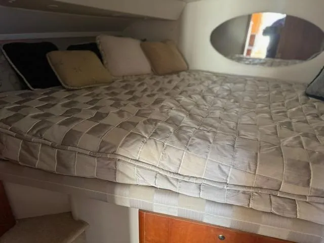 Slide: The Image of Cozy cabin interior of 2002 Silverton 330 Sport Bridge with plush bedding and pillows. - 15