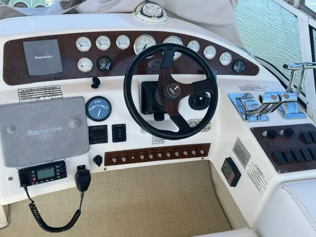 Slide: The Image of 2002 Silverton 330 Sport Bridge helm with steering wheel, gauges, and controls. - 4