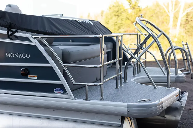 Slide: The Image of 2025 Godfrey Monaco 235 SFL pontoon boat, front view, parked on gravel. - 4