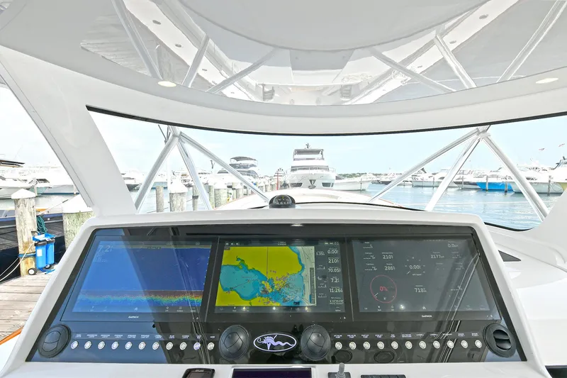 Slide: The Image of 2024 Valhalla V-55 Center Console dashboard with advanced navigation displays at marina. - 18
