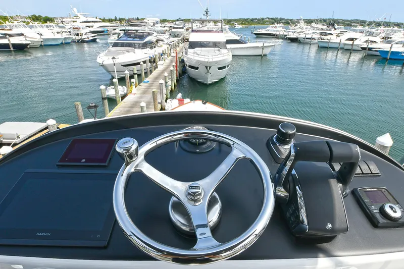 Slide: The Image of 2024 Valhalla V-55 Center Console helm overlooking marina with luxury yachts. - 23