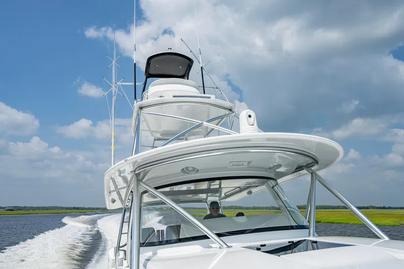 Slide: The Image of 2024 Valhalla V-55 Center Console boat cruising on open water under a cloudy sky. - 24