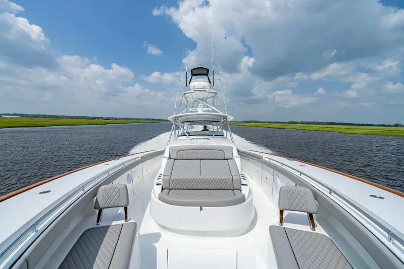 Slide: The Image of 2024 Valhalla V-55 Center Console cruising on a scenic waterway under a blue sky. - 26