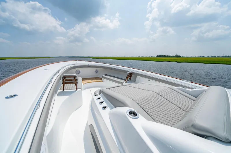 Slide: The Image of 2024 Valhalla V-55 Center Console boat with luxurious seating on a calm waterway. - 27