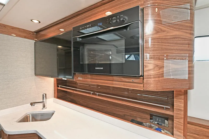 Slide: The Image of 2024 Valhalla V-55 Center Console interior with modern kitchen amenities. - 35