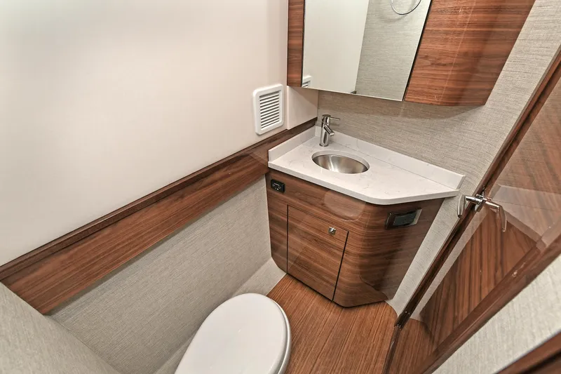 Slide: The Image of 2024 Valhalla V-55 Center Console bathroom with wood accents and modern fixtures. - 37