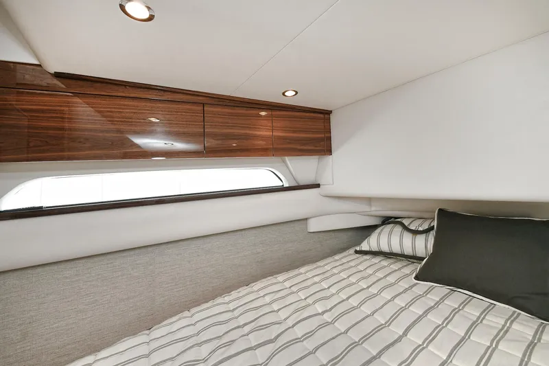 Slide: The Image of 2024 Valhalla V-55 Center Console cabin with modern wood cabinetry and cozy bedding. - 39