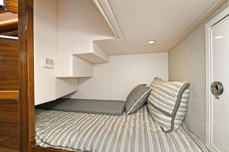 Slide: The Image of 2024 Valhalla V-55 Center Console cabin with striped bedding and modern design. - 41