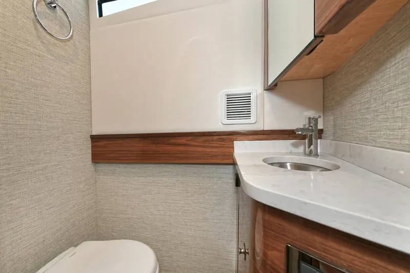 Slide: The Image of 2024 Valhalla V-55 Center Console bathroom with modern sink and wood accents. - 42