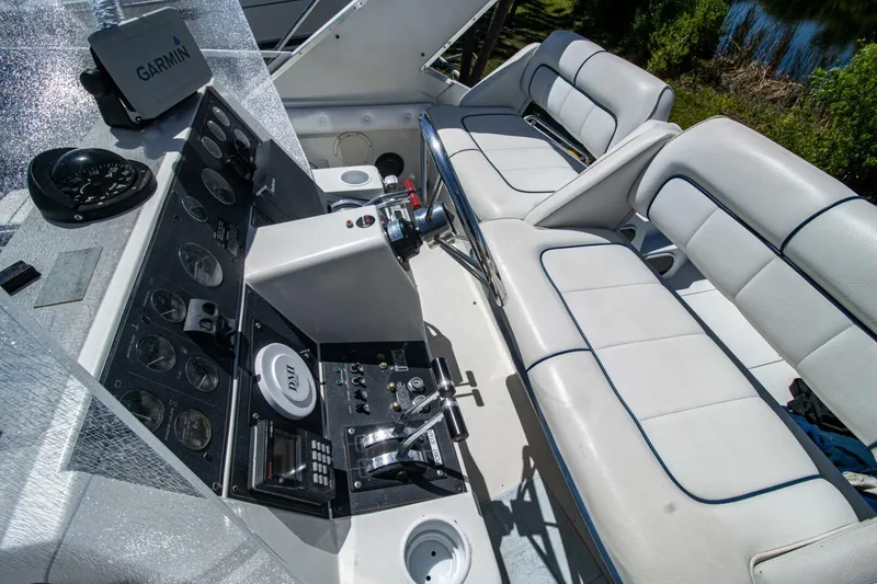 Slide: The Image of 1989 Carver 340 Santego boat interior with helm, controls, and white seating. - 13
