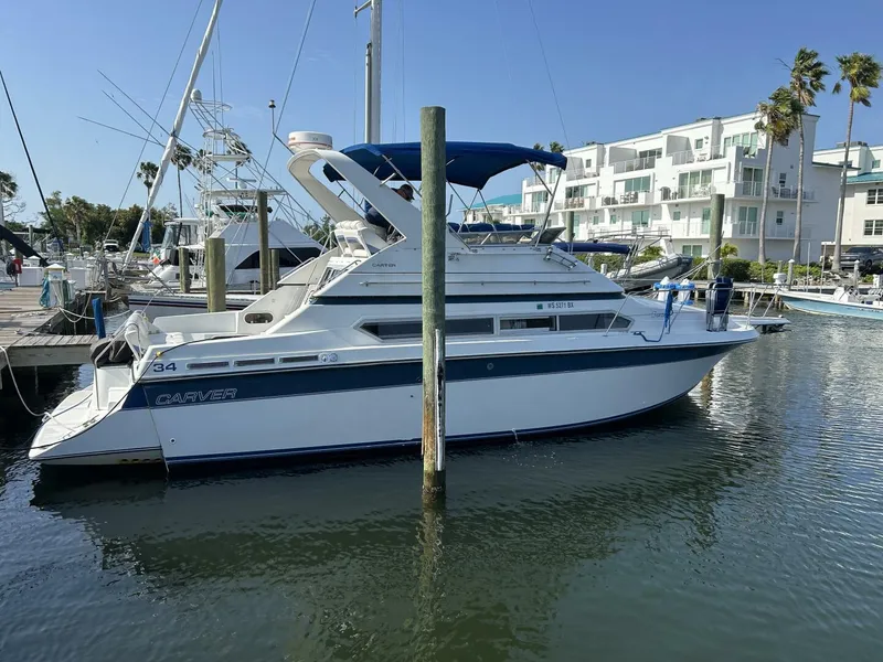The Image of 1989 Carver 340 Santego yacht docked at marina with blue canopy. - 1