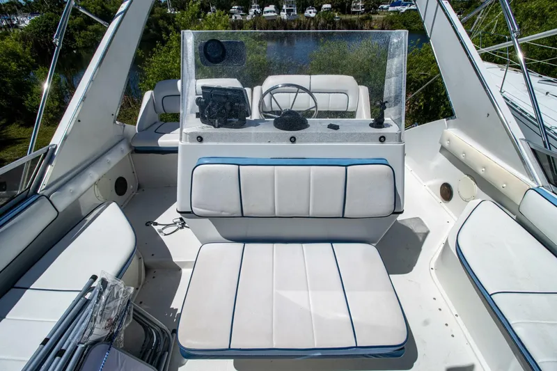 Slide: The Image of 1989 Carver 340 Santego boat interior with white seating and steering console. - 11