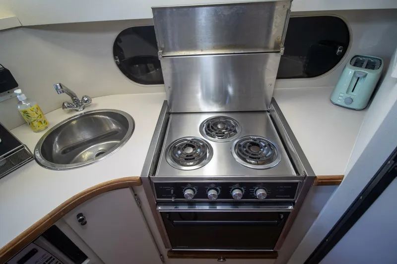 Slide: The Image of 1989 Carver 340 Santego yacht kitchen with stove, sink, and appliances. - 19