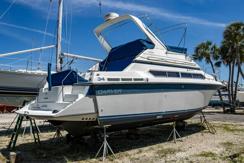 Slide: The Image of 1989 Carver 340 Santego yacht on stands, blue and white design, sunny day. - 3