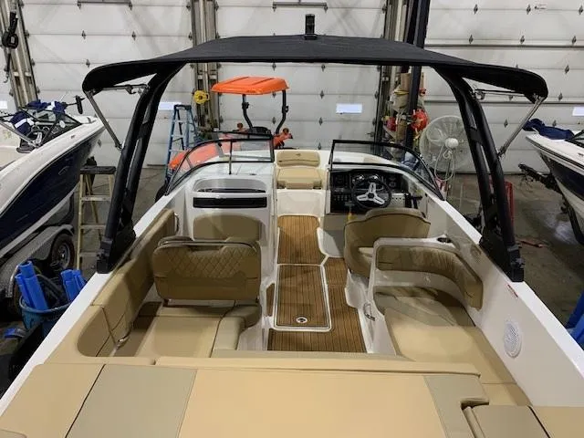 Slide: The Image of 2025 Bayliner VR6 Bowrider I/O with tan interior, docked in a garage setting. - 4