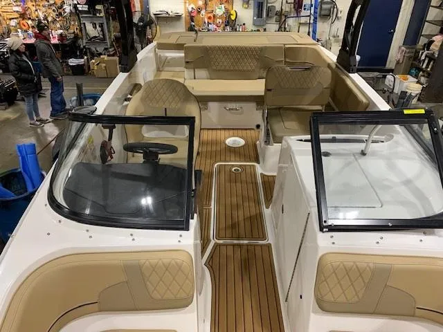 Slide: The Image of 2025 Bayliner VR6 Bowrider I/O with tan interior and wood flooring in a workshop setting. - 5