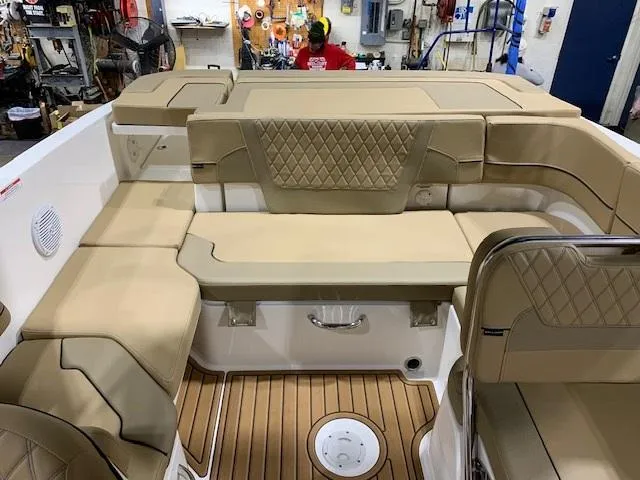 Slide: The Image of 2025 Bayliner VR6 Bowrider I/O interior with tan seating and wood-style flooring. - 6