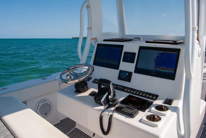 Slide: The Image of 2023 Front Runner 33 Center Console boat dashboard with navigation screens and steering wheel. - 22