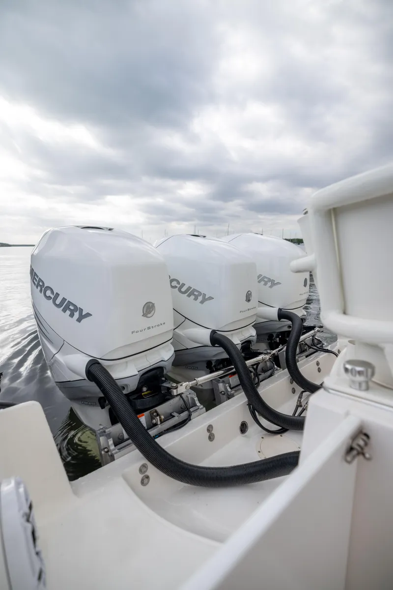 Slide: The Image of 2007 Fountain 34 Center Console with triple Mercury outboard engines on a cloudy day. - 10