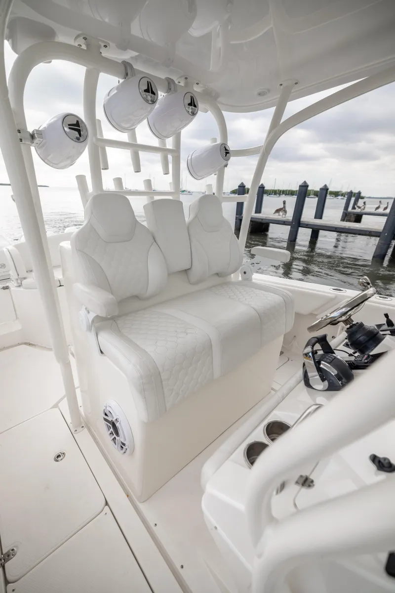 Slide: The Image of 2007 Fountain 34 Center Console boat interior with white seating and speakers. - 11
