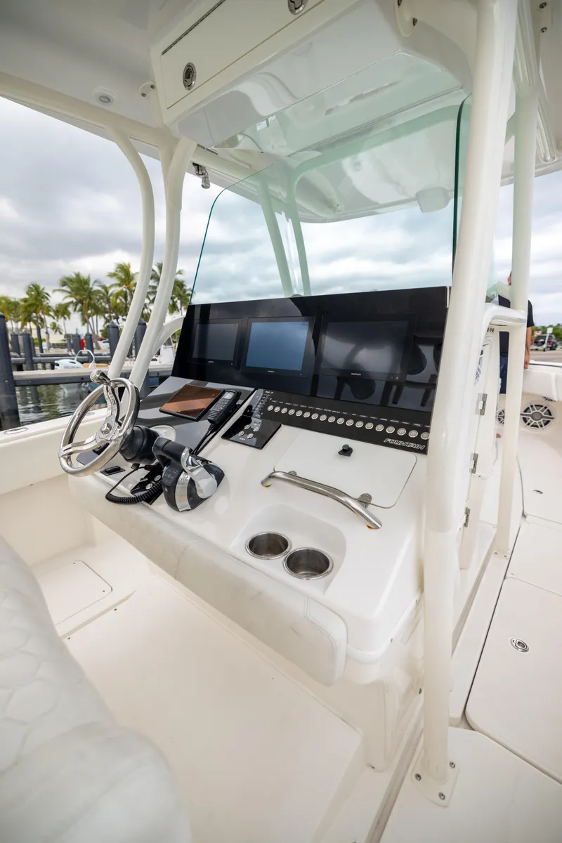 Slide: The Image of 2007 Fountain 34 Center Console boat dashboard with steering wheel and controls. - 14