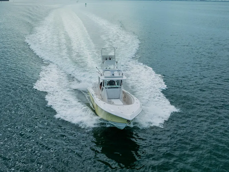 Slide: The Image of 2007 Fountain 34 Center Console boat cruising on open water, leaving a wake trail. - 4