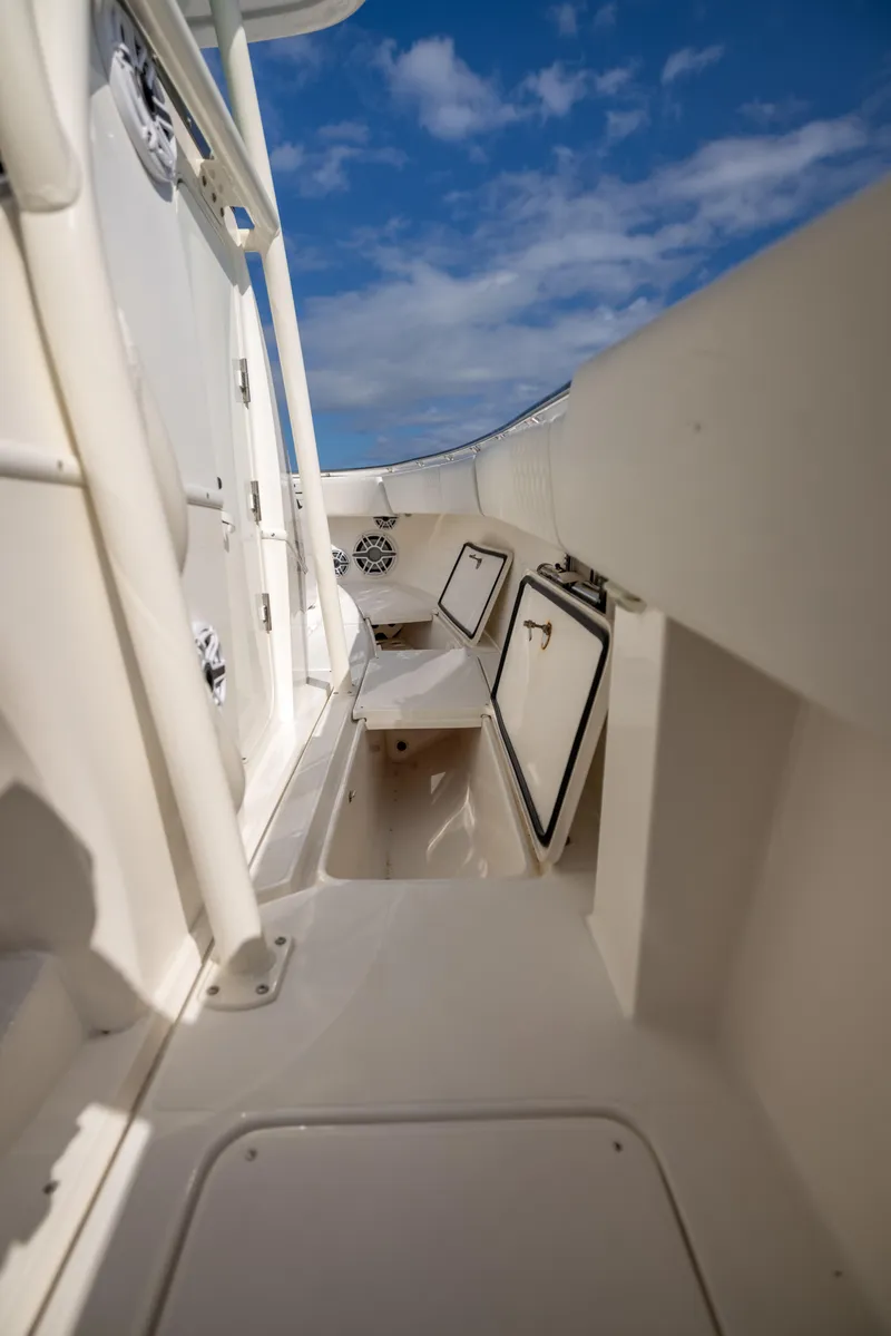 Slide: The Image of 2007 Fountain 34 Center Console boat interior with storage compartments, under a clear blue sky. - 7