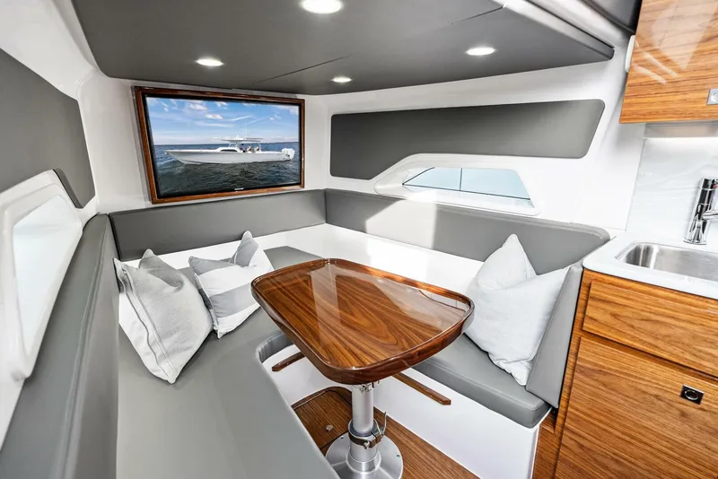 Slide: The Image of Interior of 2025 Valhalla Boatworks V-46, featuring a sleek seating area and wooden table. - 29