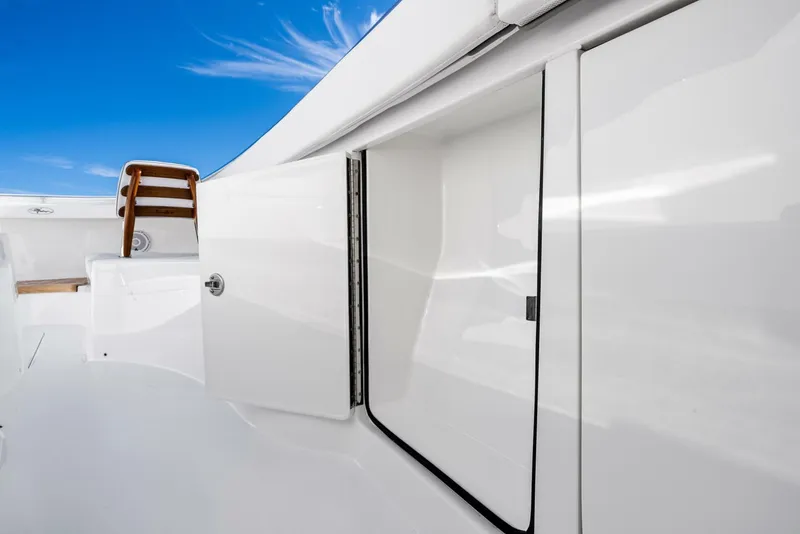 Slide: The Image of 2025 Valhalla Boatworks V-46 deck with open storage compartment under clear blue sky. - 44