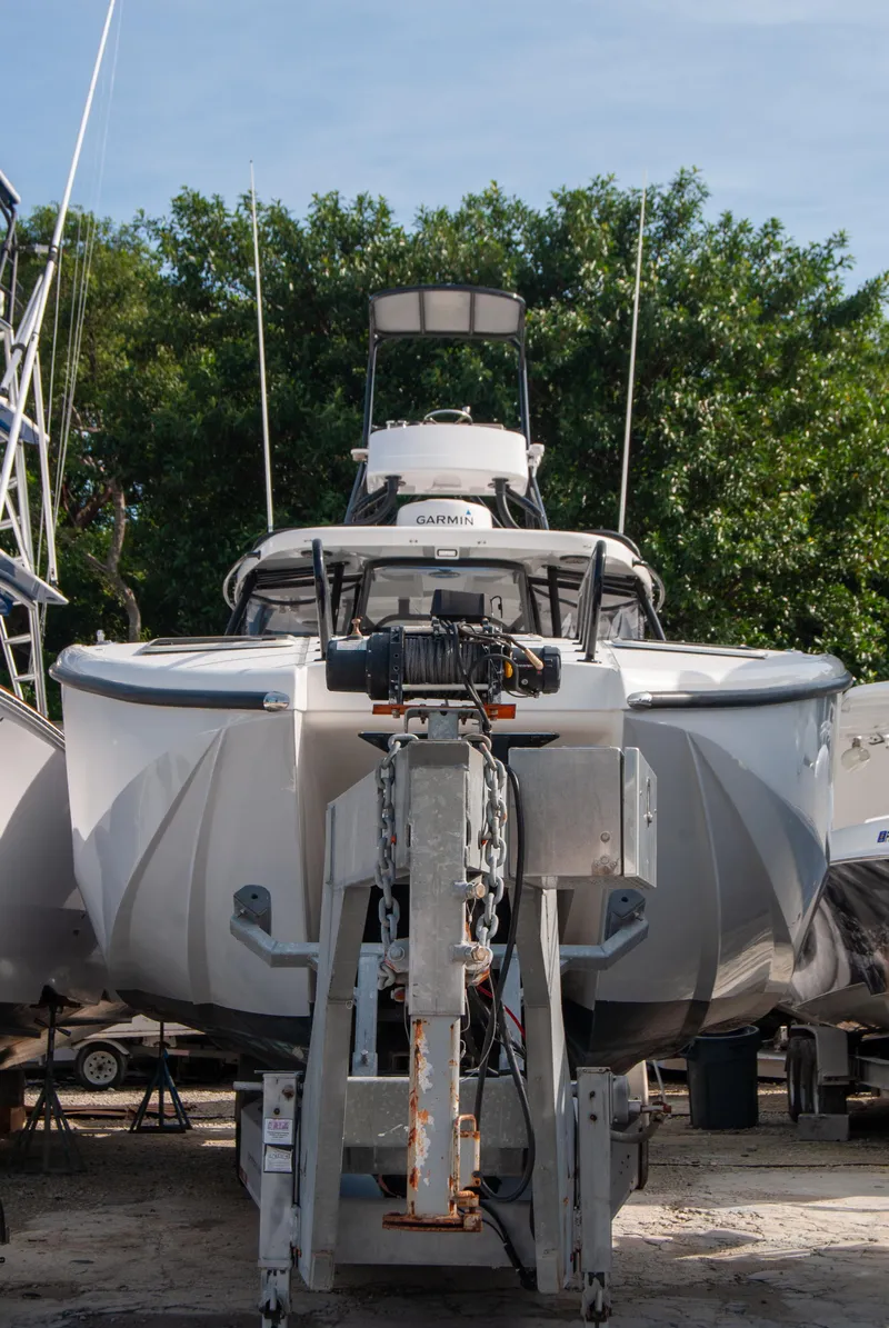 Slide: The Image of 2014 Insetta i45C boat on trailer, front view, surrounded by trees. - 1