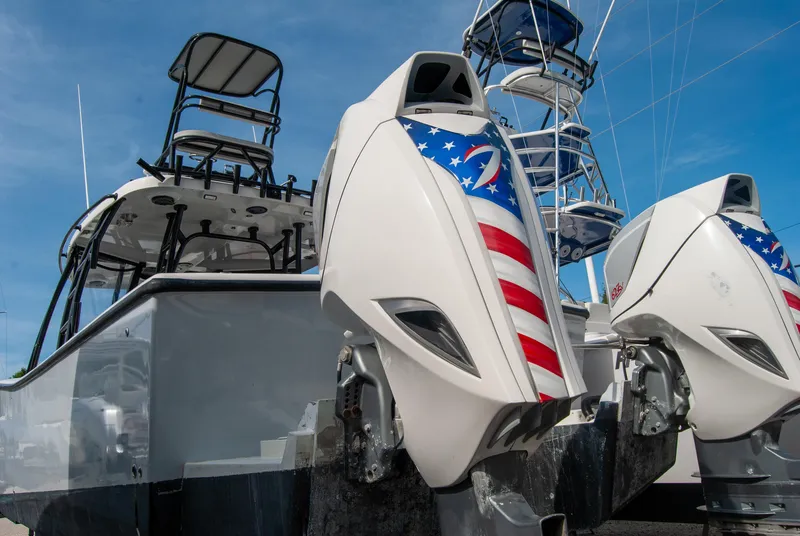 Slide: The Image of 2014 Insetta i45C boat with patriotic-themed outboard motors under a clear blue sky. - 26