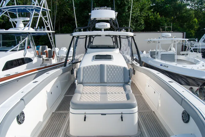 Slide: The Image of 2014 Insetta i45C boat with cushioned seating, docked among other vessels. - 4