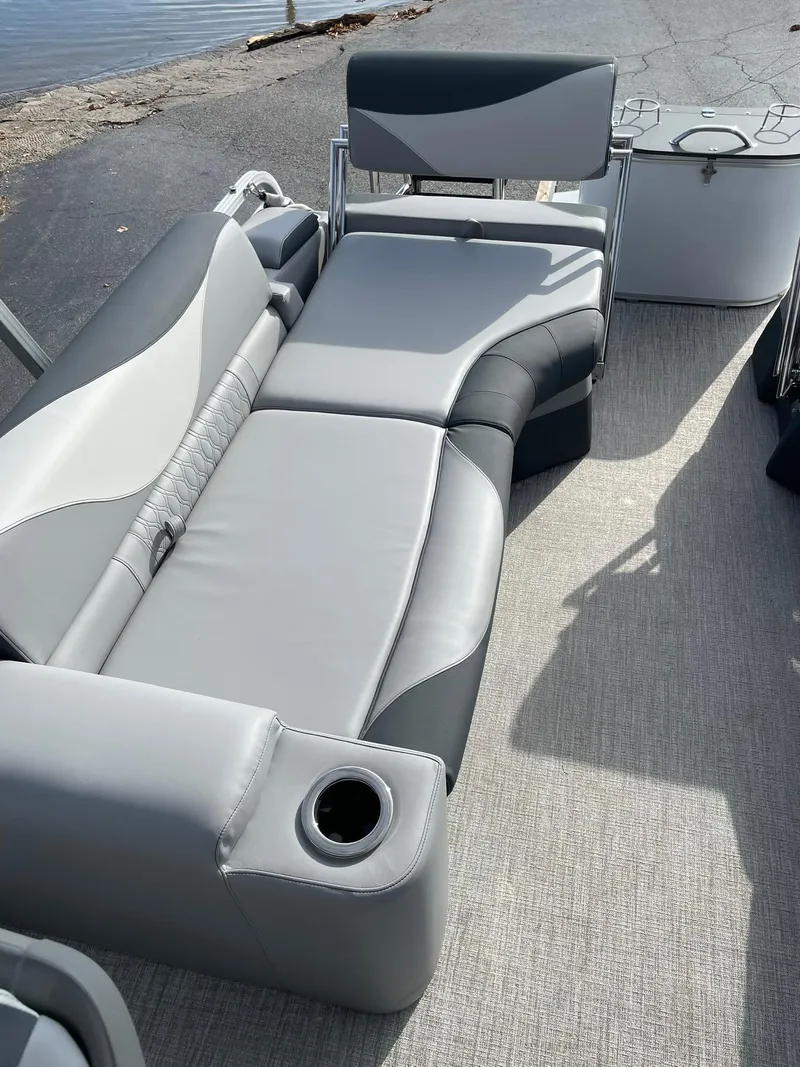 Slide: The Image of 2025 Avalon LSZ Quad Lounger Shift boat interior with gray seating and cup holder. - 15