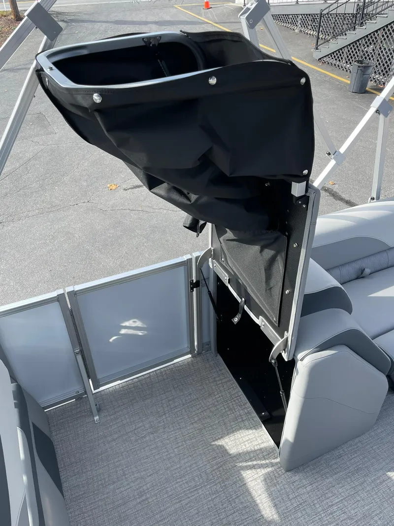 Slide: The Image of 2025 Avalon LSZ Quad Lounger Shift boat interior with storage compartment open. - 19