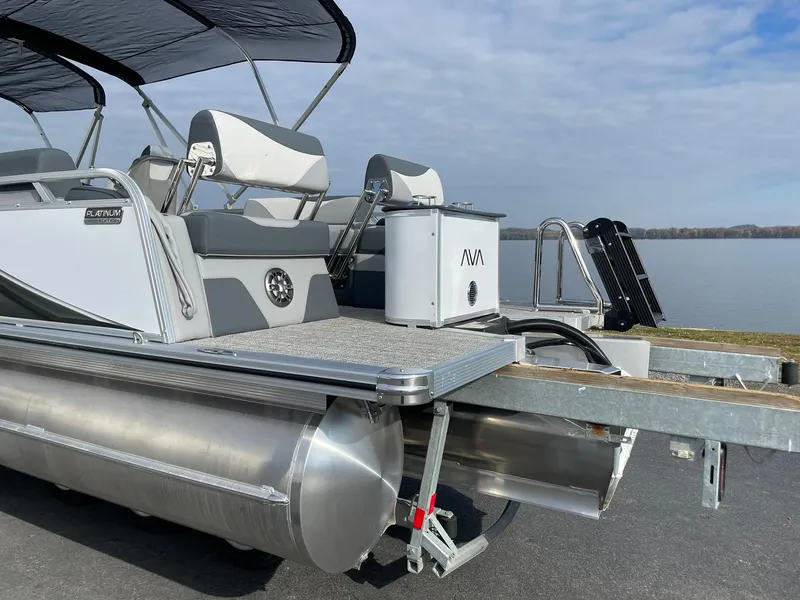 Slide: The Image of 2025 Avalon LSZ Quad Lounger Shift pontoon boat by a lake. - 4
