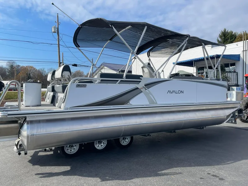 Slide: The Image of 2025 Avalon LSZ Quad Lounger Shift pontoon boat with canopy in a parking lot. - 6