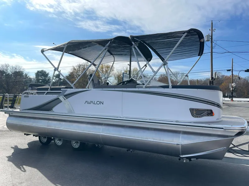 Slide: The Image of 2025 Avalon LSZ Quad Lounger Shift pontoon boat with canopy, parked outdoors. - 7