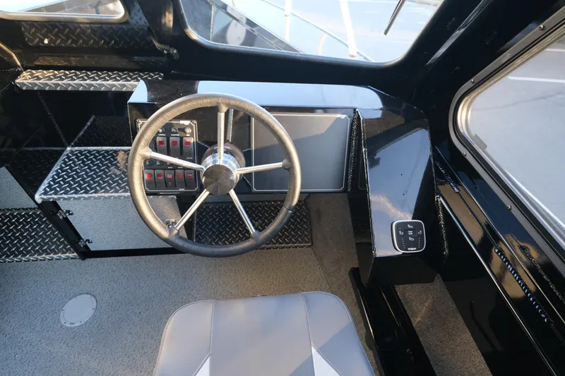 Slide: The Image of Interior of 2025 Hewescraft 220 Ocean Pro ET HT boat, featuring steering wheel and control panel. - 16