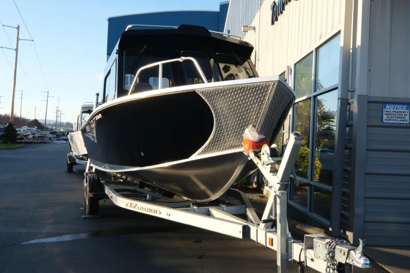 Slide: The Image of 2025 Hewescraft 220 Ocean Pro ET HT boat on trailer, parked outside a building. - 3